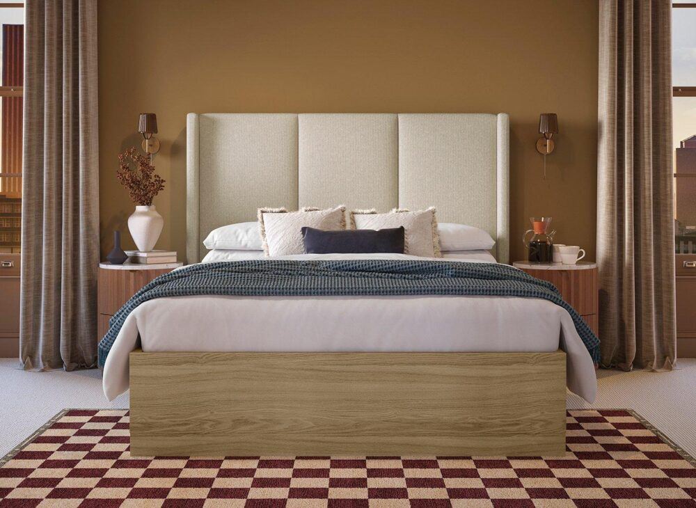 An upholstered and wooden bed frame, with a checkered rug