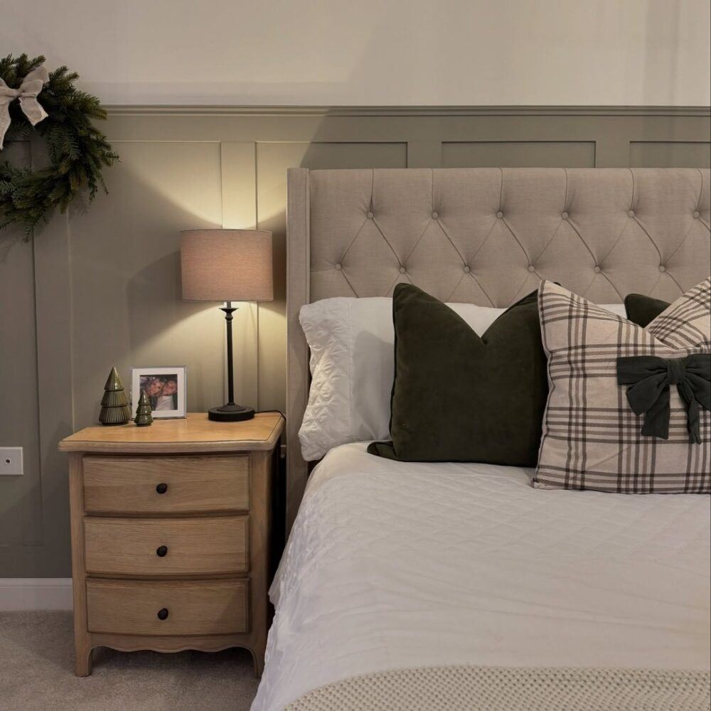 Bedroom by @houseofaspaniel featuring light grey Deacon bed with button detailing and festive bow bedding. Wall features light green panelling.