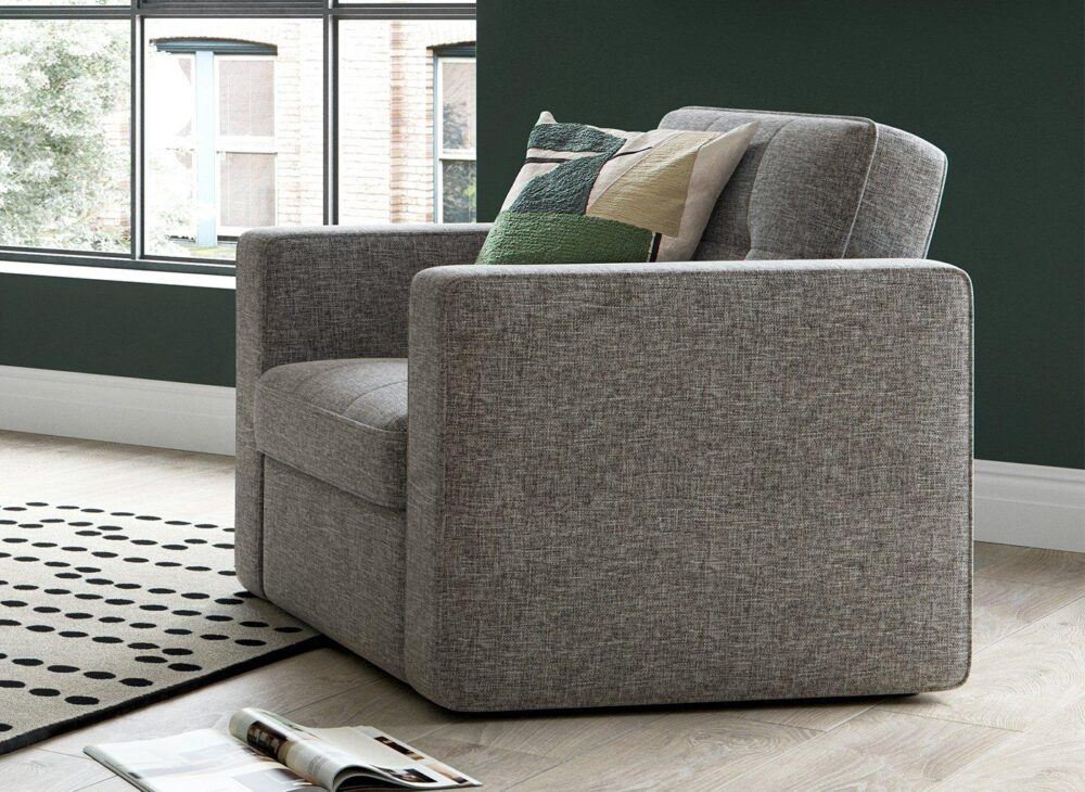 Haze Arm chair in grey upholstery, styled with a green cushion and a room with dark green walls