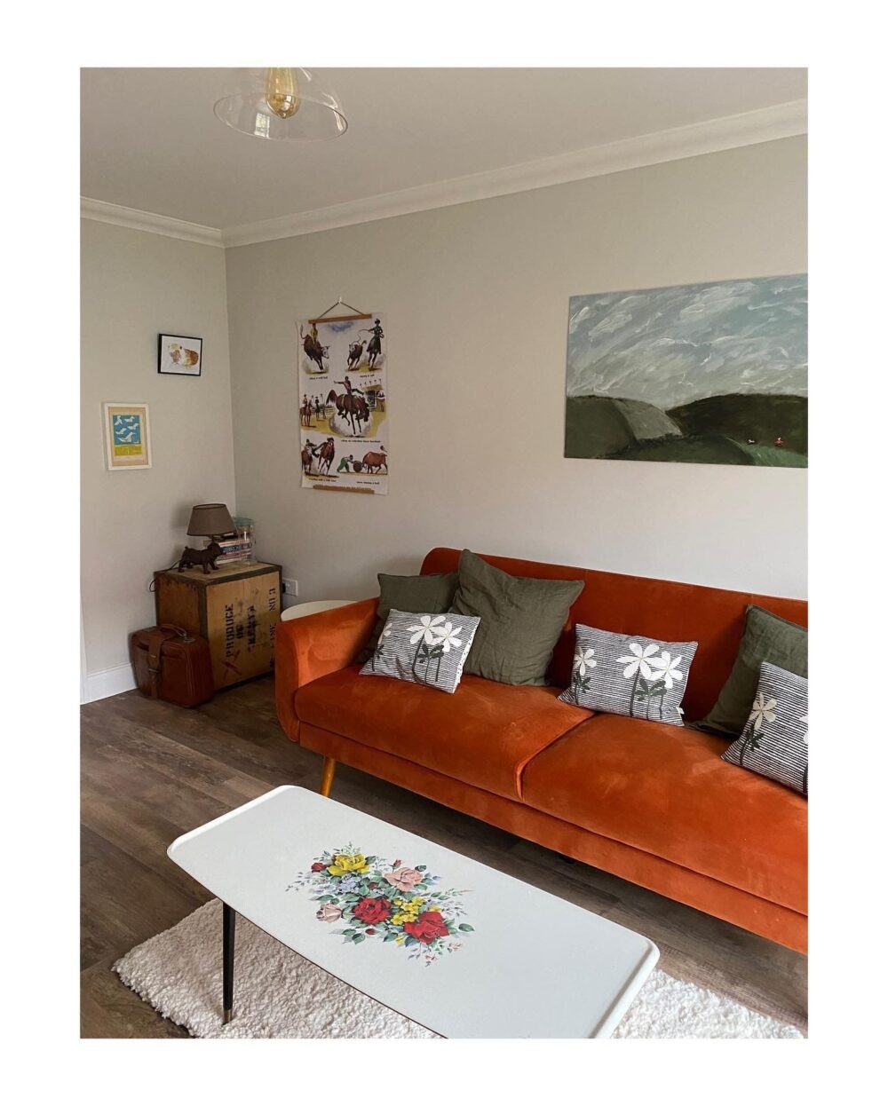 Burnt orange sofa bed with green cushions