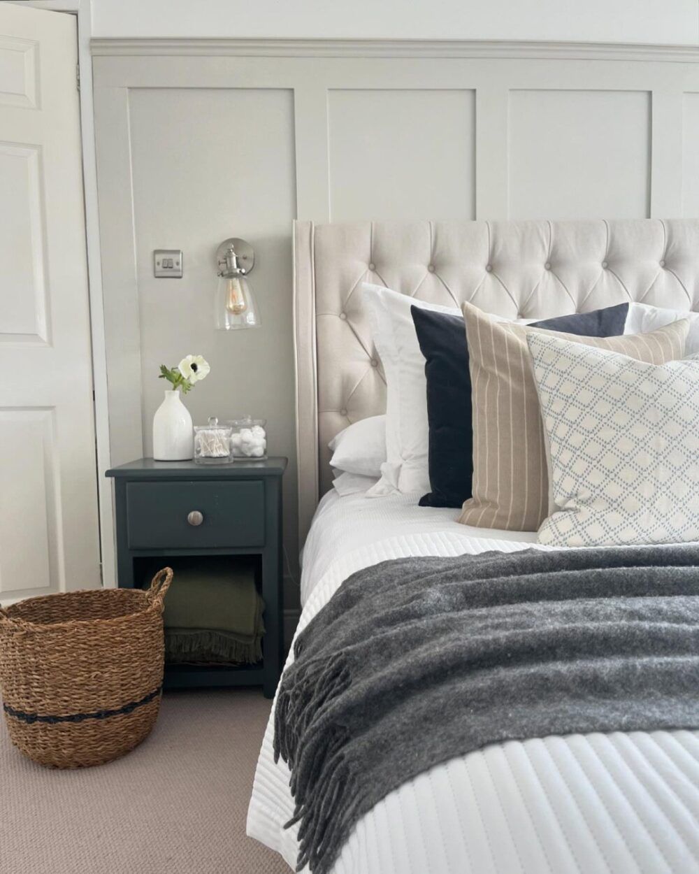 A white and grey wall panelled bedroom with grey and navy accents, UGC by alookinside25