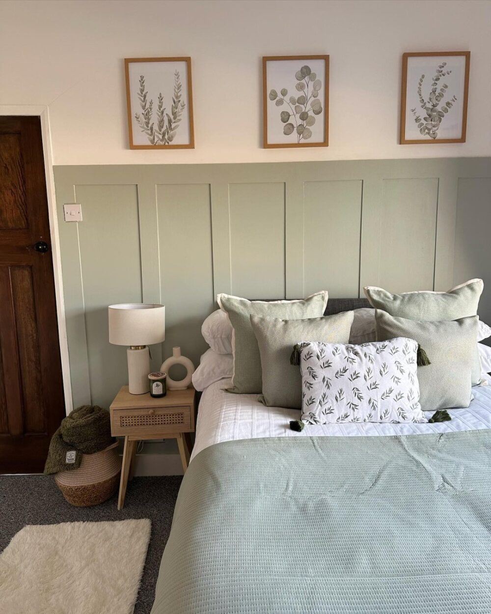 UGC created by @homebyholli featuring sage green and white bedroom styling, a panelled green wall and 3 picture frames