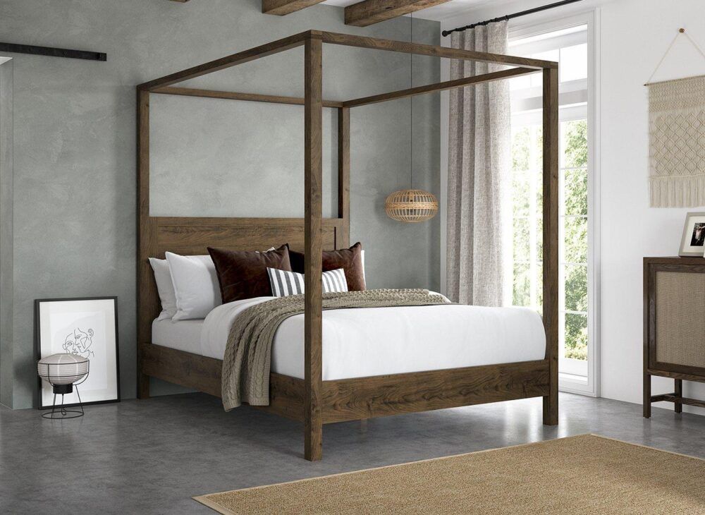 image of a four poster wooden bed frame against a grey backdrop wall