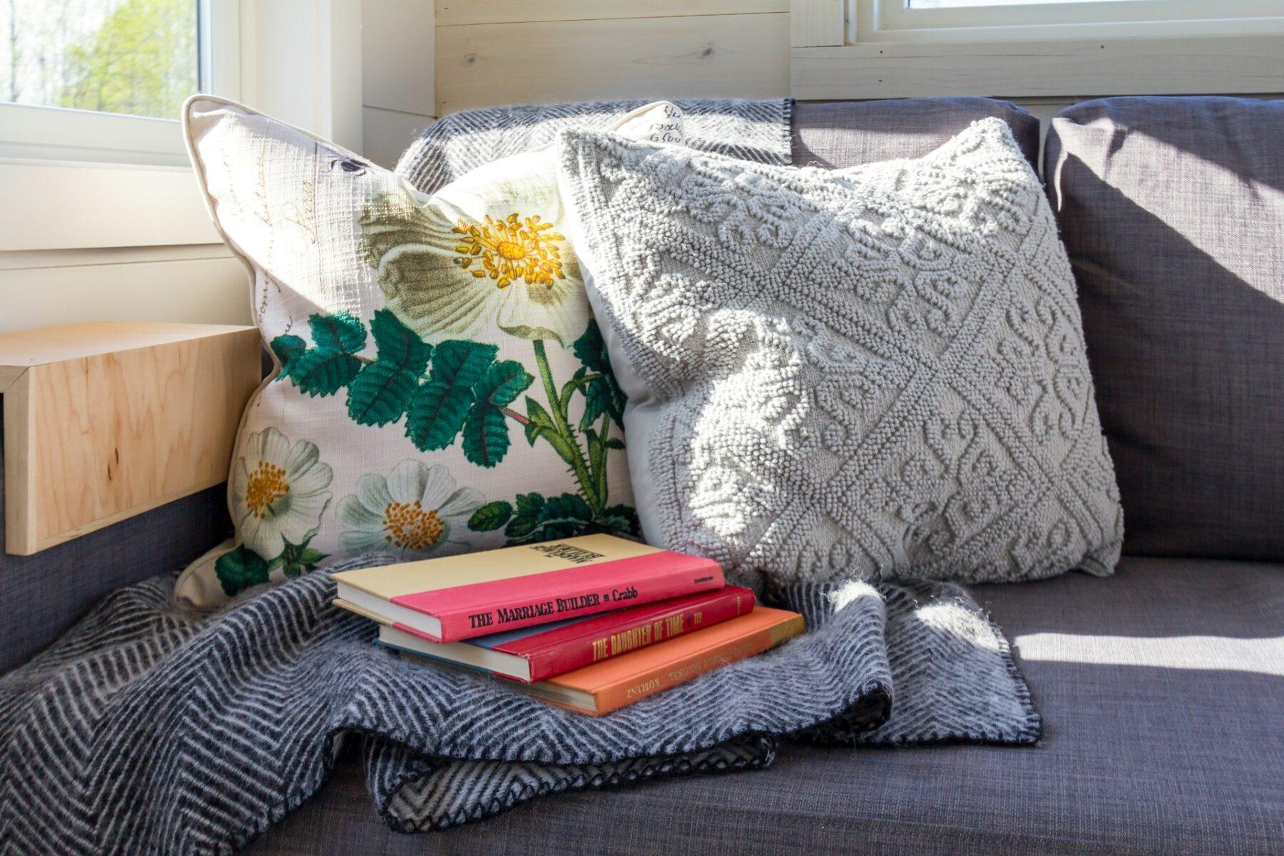 image of a comfy reading nook with pillows and books and sunlight coming in