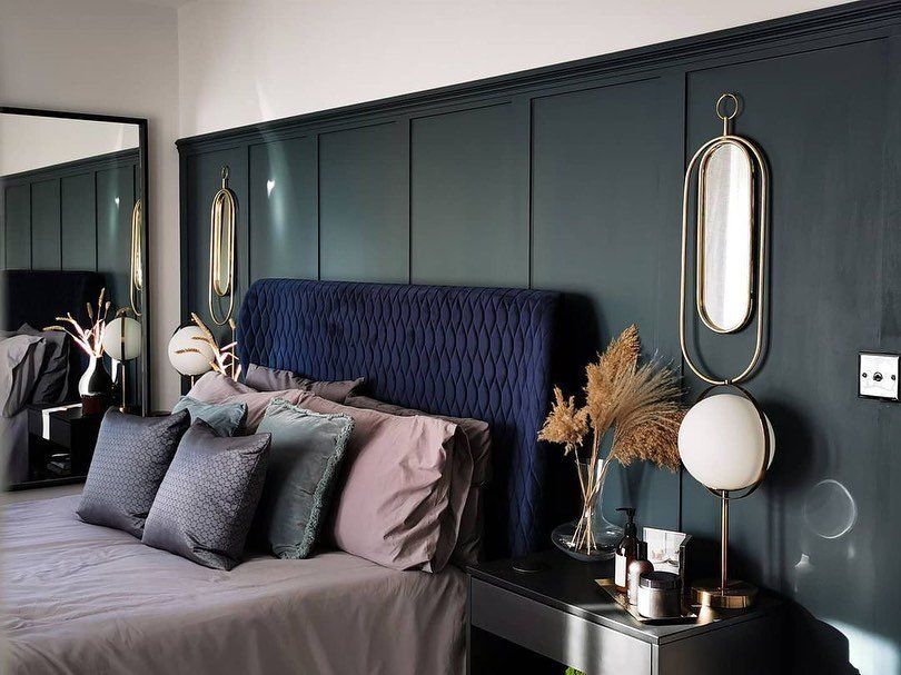 Bedroom with green wall panelling and blue bed frame