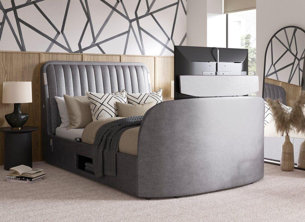 Grey velvet-touch TV bed with fluted headboard, styled with grey and pink accessories