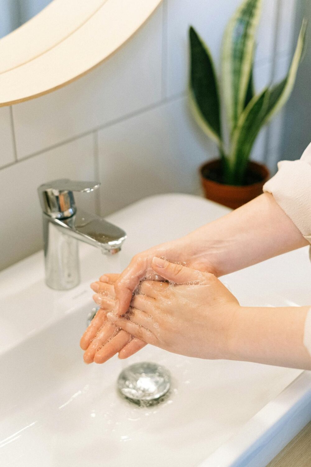 Close-up of hands being washed in soapy water