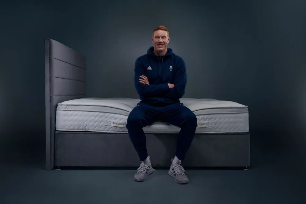 Tom Dean MBE, Team GB swimmer, sat on a Dreams mattress