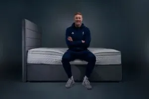 Tom Dean MBE, Team GB swimmer, sat on a Dreams mattress