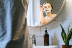 Person wearing a skin care mask looking in the mirror