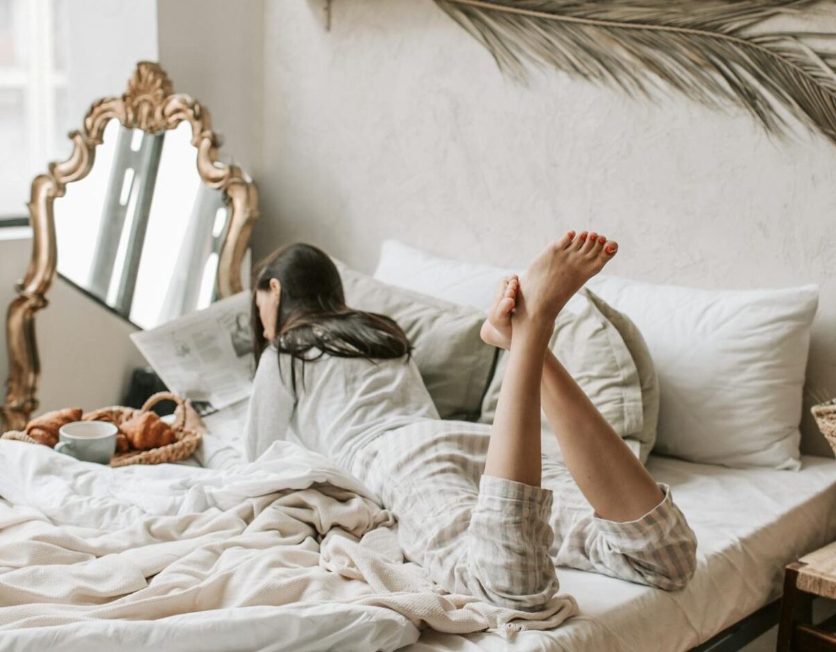 Woman relaxing on bed with legs crossed