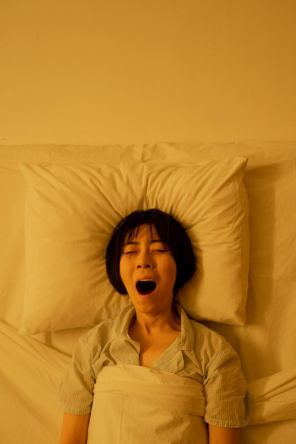 Woman yawning in bed