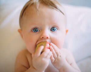 teething baby chewing on toy
