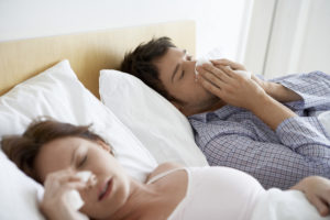 couple in bed with tissues as they are suffering from hayfever