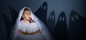 Young girl having nightmares in bed
