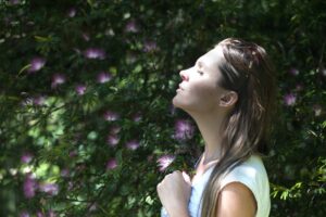 A woman practising breathing exercises outside.